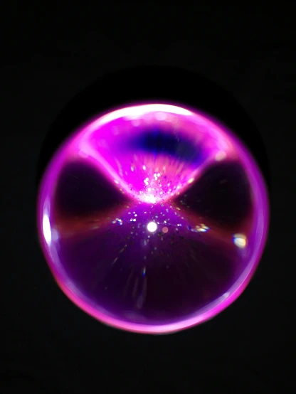 a close up view of a purple circular object in the dark