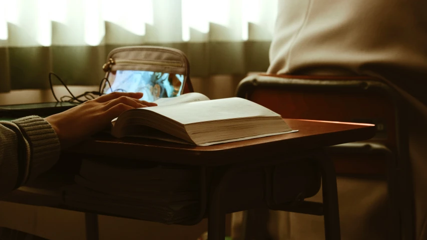 a person with a hand on an open book