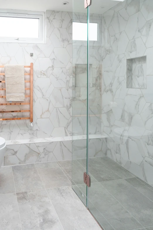 a tiled bathroom has a shower and a white toilet