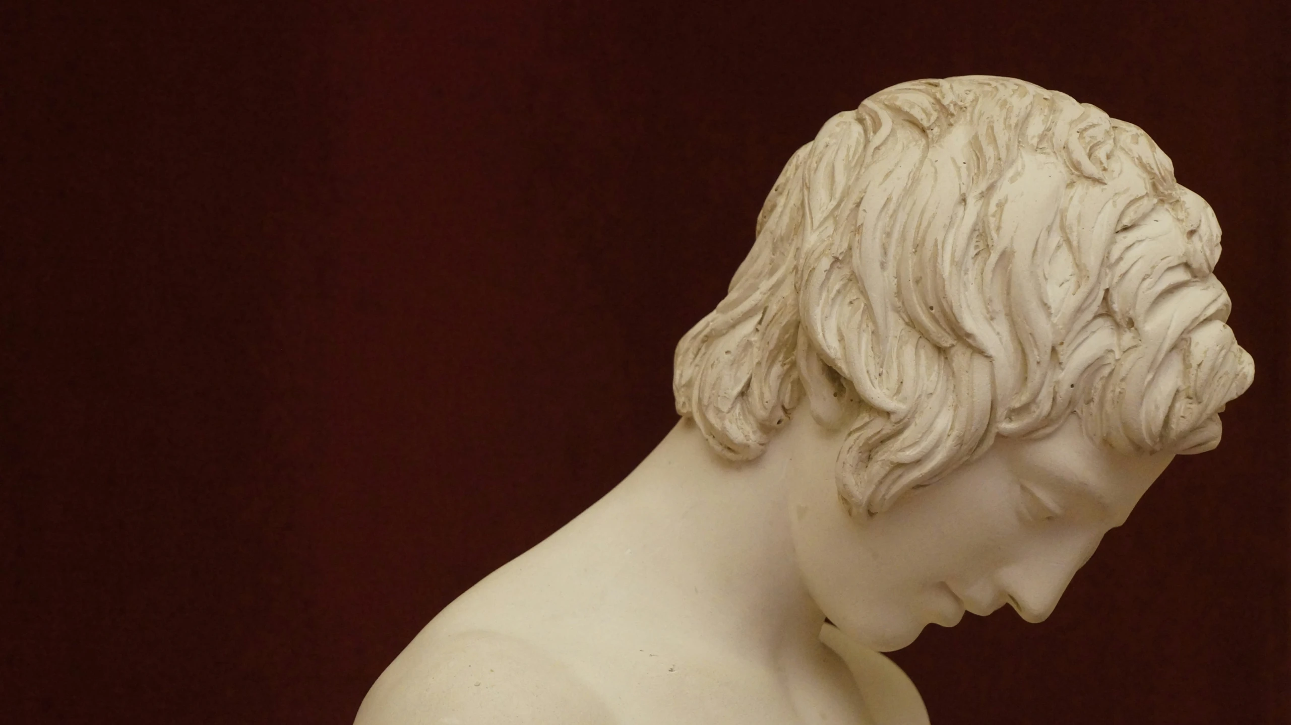 a sculpture of a young man head is in profile