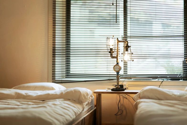 a table with a lamp on it sits between two twin beds