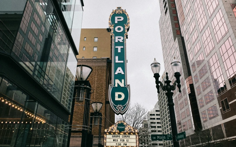 looking up at a green sign that says portland