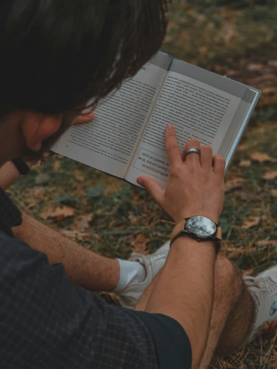 a man is sitting down reading a book