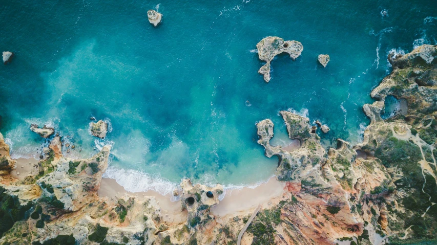 an aerial view of the beach with some boats