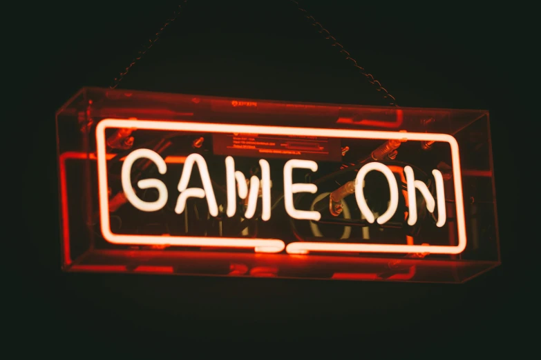 game on neon sign in black and red