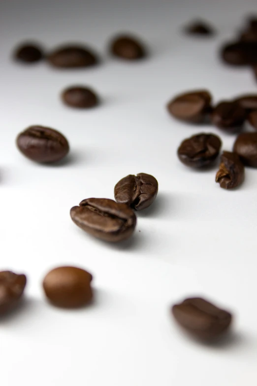 a pile of roasted coffee beans on a white table