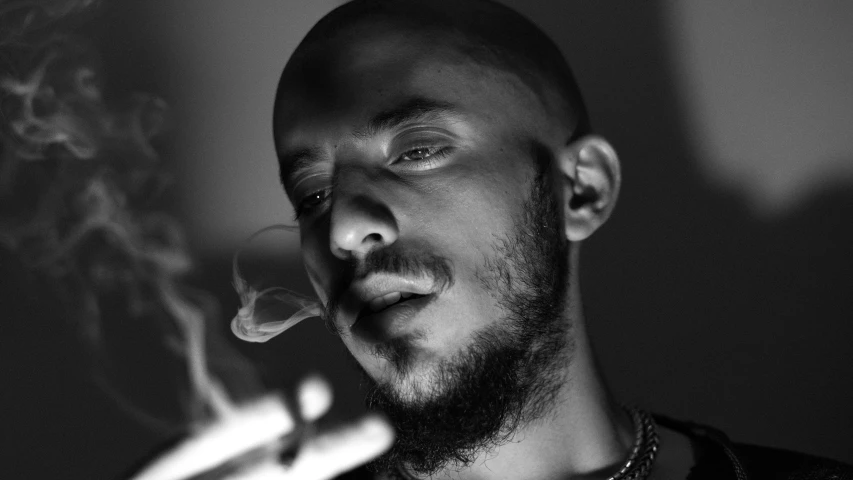 a man smoking a cigarette in black and white