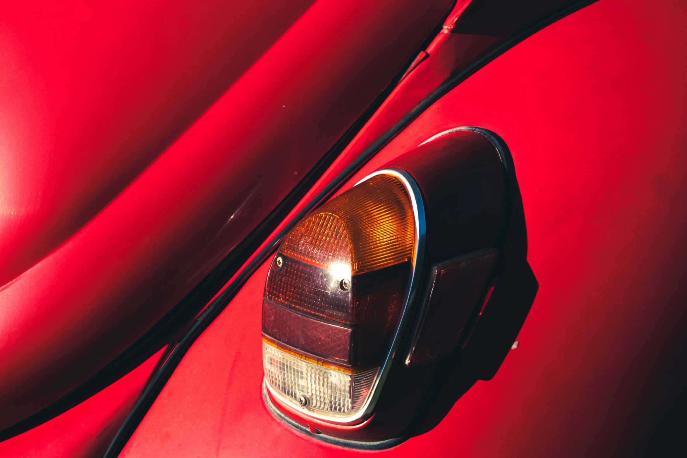 the side view of a vintage red car with the taillight on