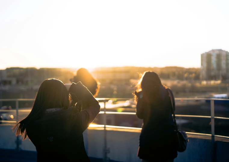 a couple of women standing on top of a rooftop