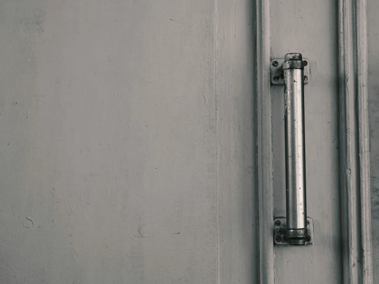 the side of a gray wall with an angled door handle