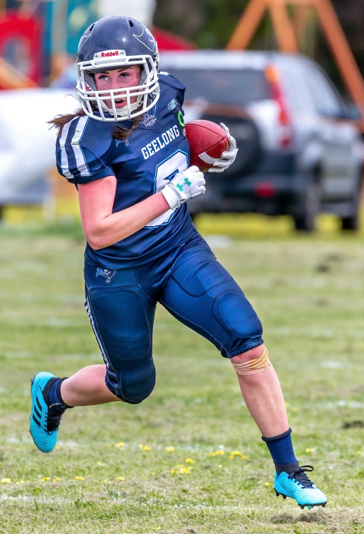 young football player running with ball in field