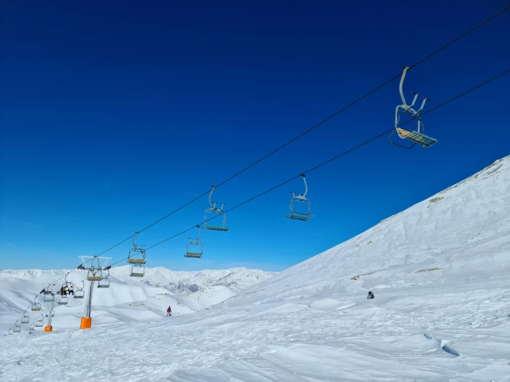 ski lift with chairs and people on the slope in snow