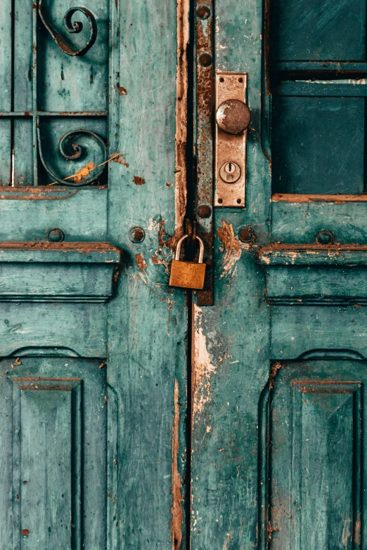 an old blue door has a padlock on the front door