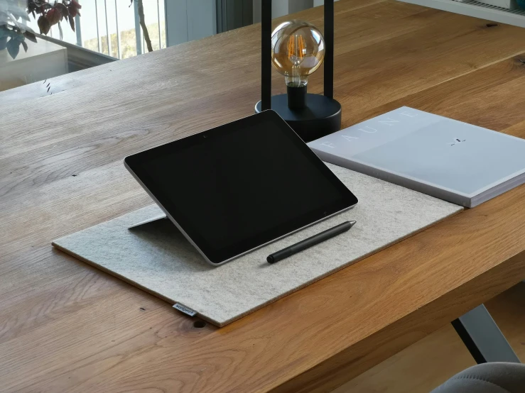 a tabletop on a desk with a laptop and pen