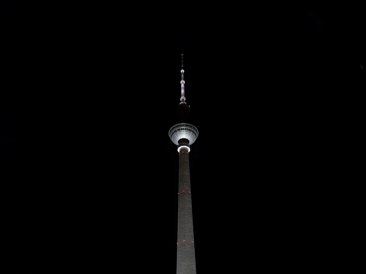 a large tower at night in the dark with its lights on