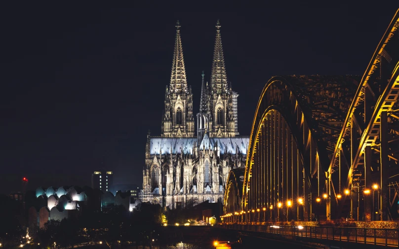 a large cathedral at night with other tall buildings