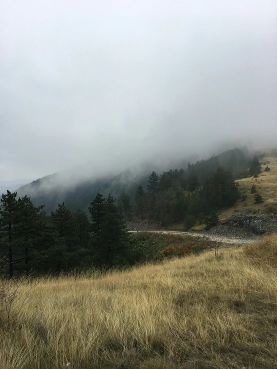 the fog is coming in over a mountain