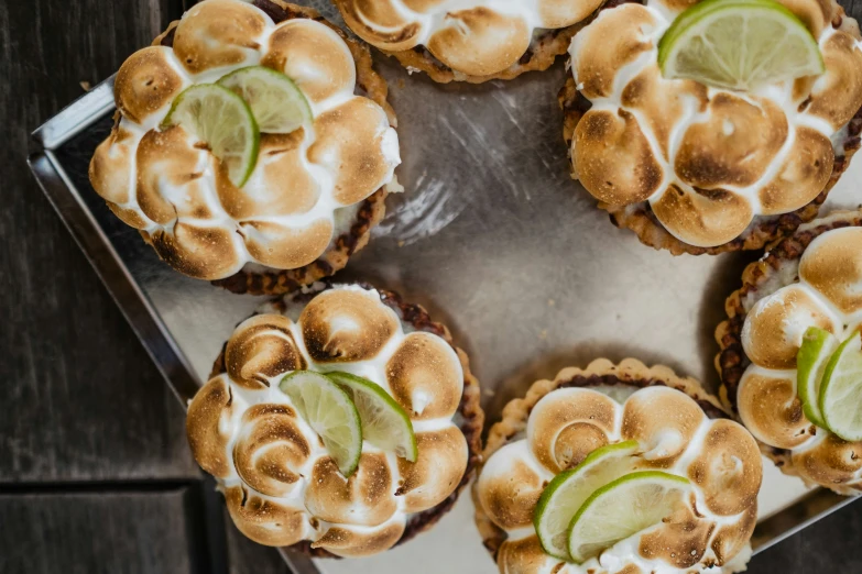 a few lime and sour cream tarts are on a sheet