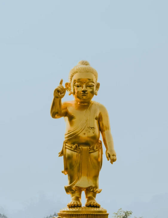 large statue of hindu god standing upright with a peace sign