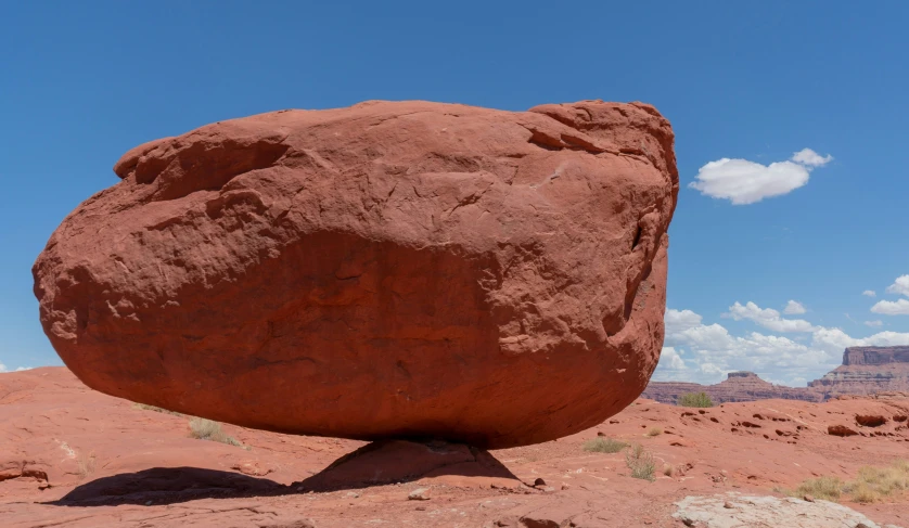 a rock sticking out of the middle of a desert