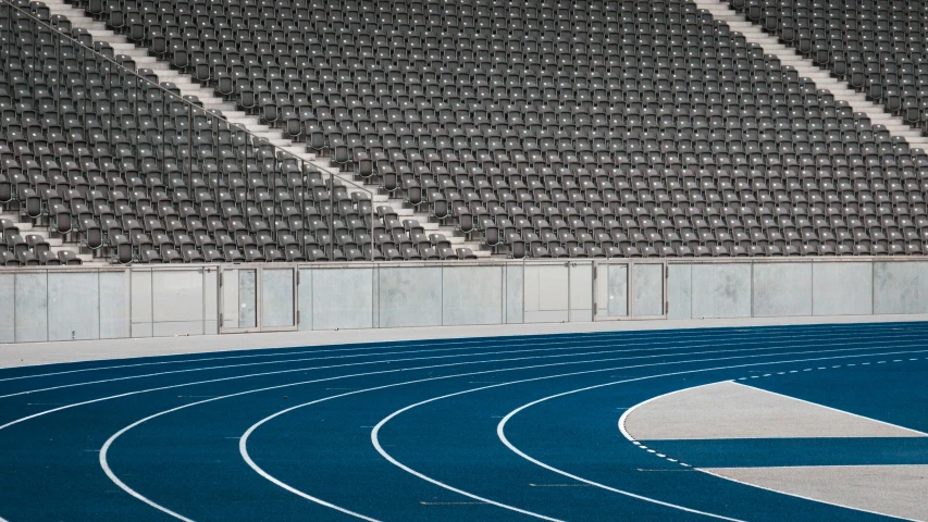 a close - up of a blue track with many empty seats in the background