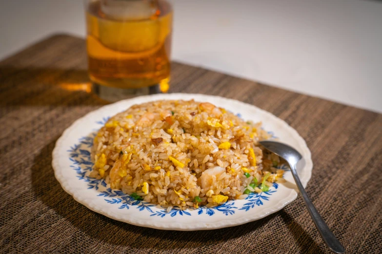 rice and corn on a plate next to a beverage