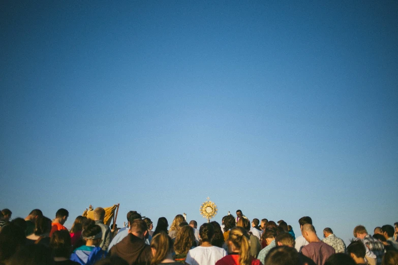 a large group of people standing under a blue sky