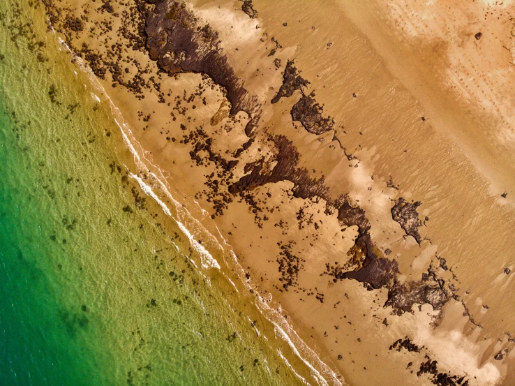 the aerial view of an ocean beach with a boat in it