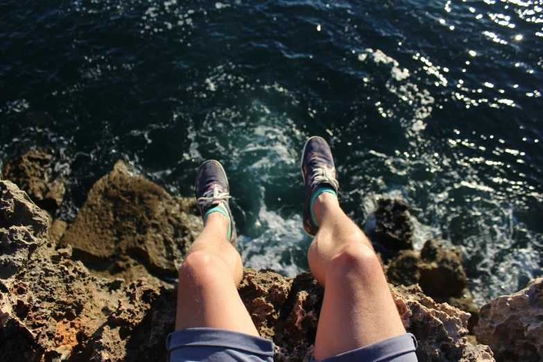 a person in blue shoes on the rocks