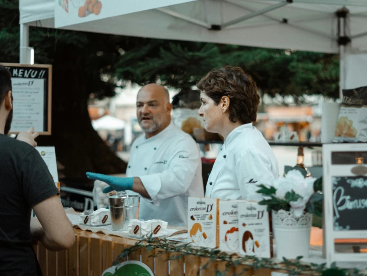 people stand at a counter getting their food from a person