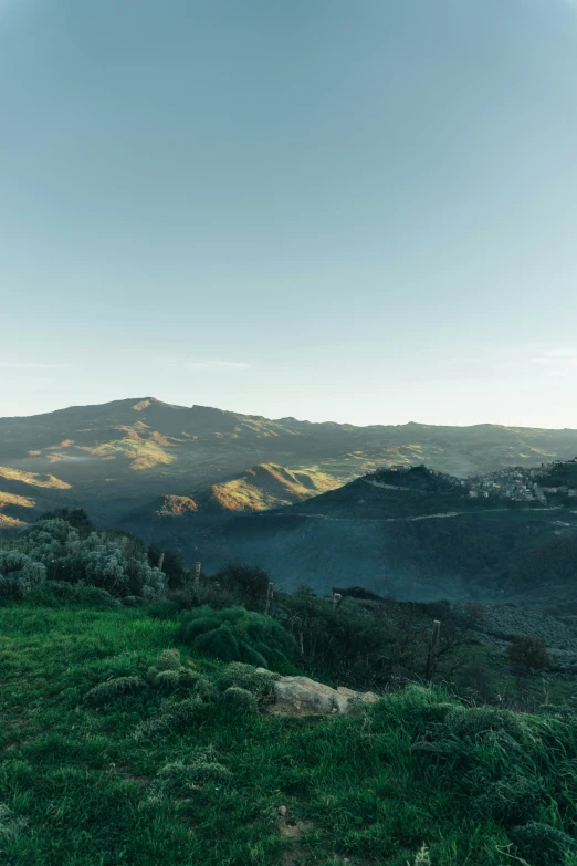 a mountain range is seen with some light green grass