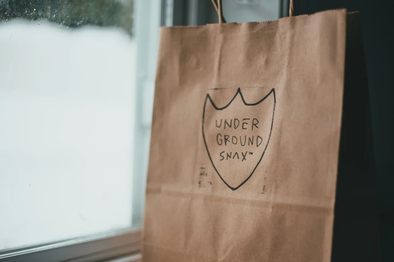 a brown paper bag with an under ground shirt on