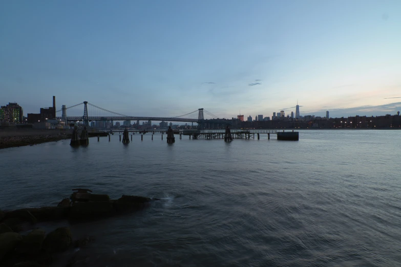 a large bridge across water and a city in the background