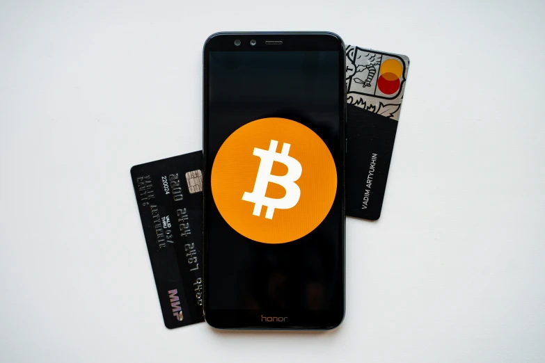 a cell phone with the bitcoin sticker on top