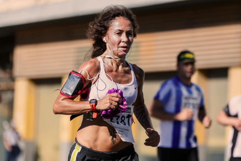 a woman running wearing a white tank top