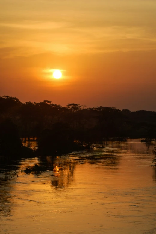 the setting sun is in the horizon above water