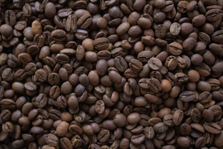 a pile of coffee beans that are brown and black