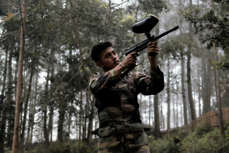 a man in camouflage shooting with a gun