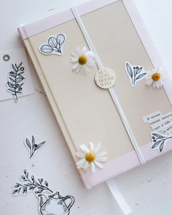 an album with paper flowers on it and some clips of stickers around the pages
