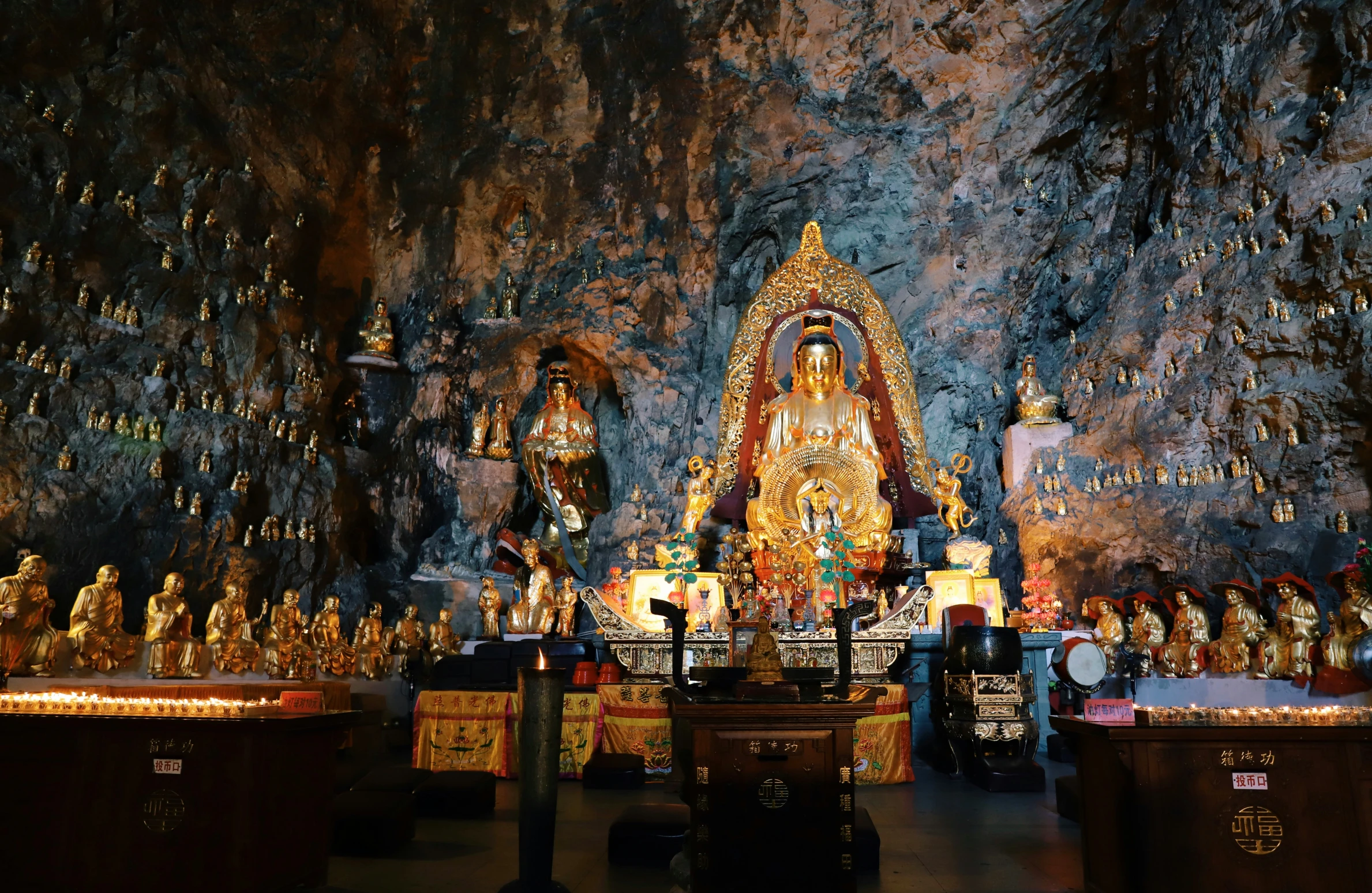 a cave with various statues of buddhas and other decorations