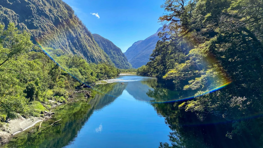 the sun is shining through the mountain tops and reflecting in the water