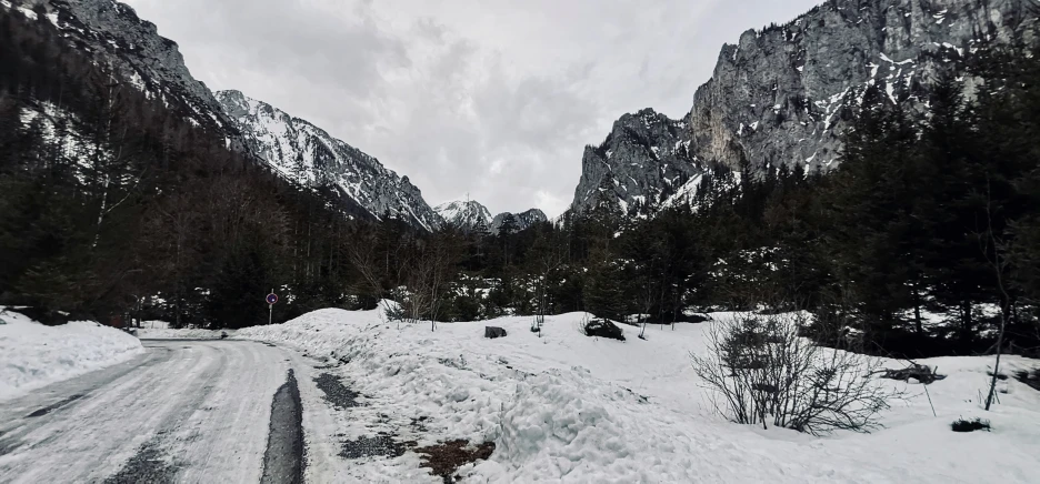 snowy roadway between two big mountains in the woods