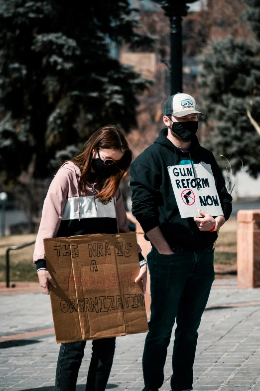 man and woman are standing in front of each other with signs