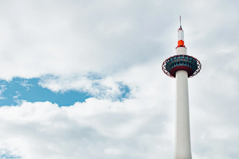 a tall white tower with a top and the sky behind it