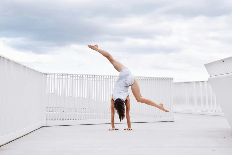 a woman doing an aerial trick on a roof