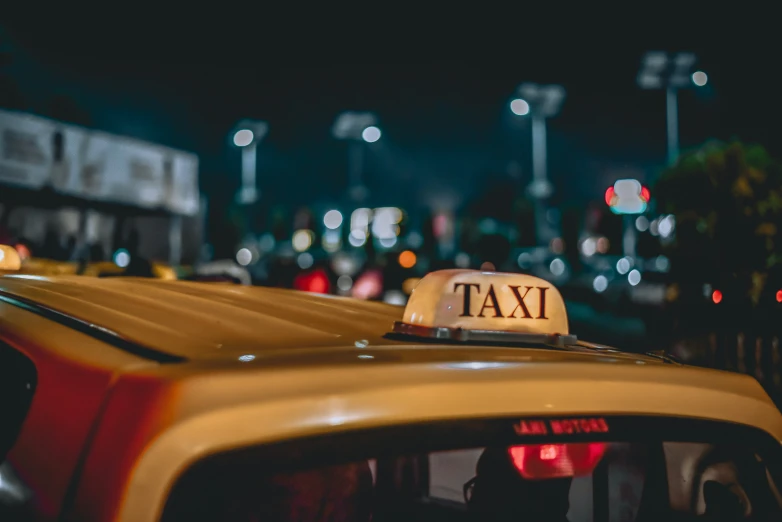 a taxi cab sitting on the side of a road with a traffic signal