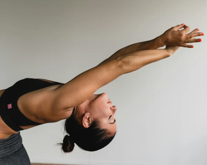 a girl is doing an arm stretch while stretching her arms and shoulders