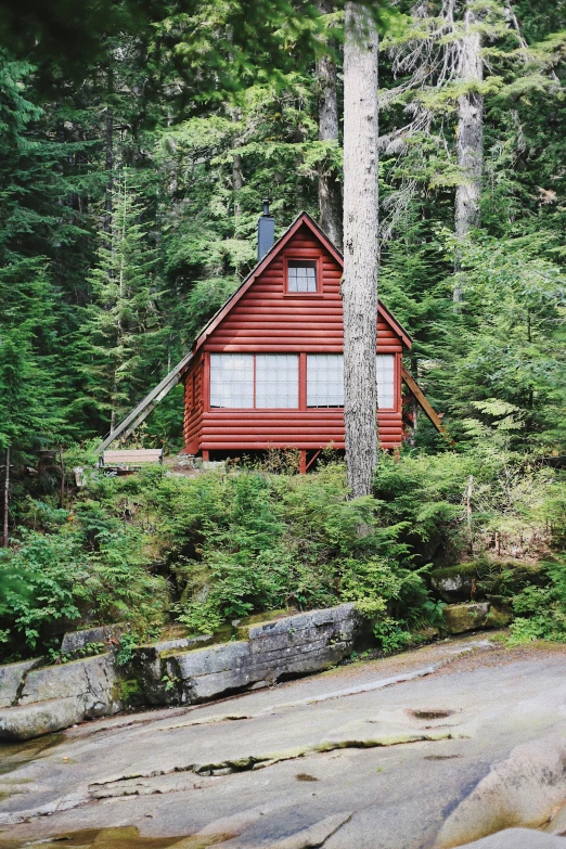 a cabin in the middle of trees near rocks