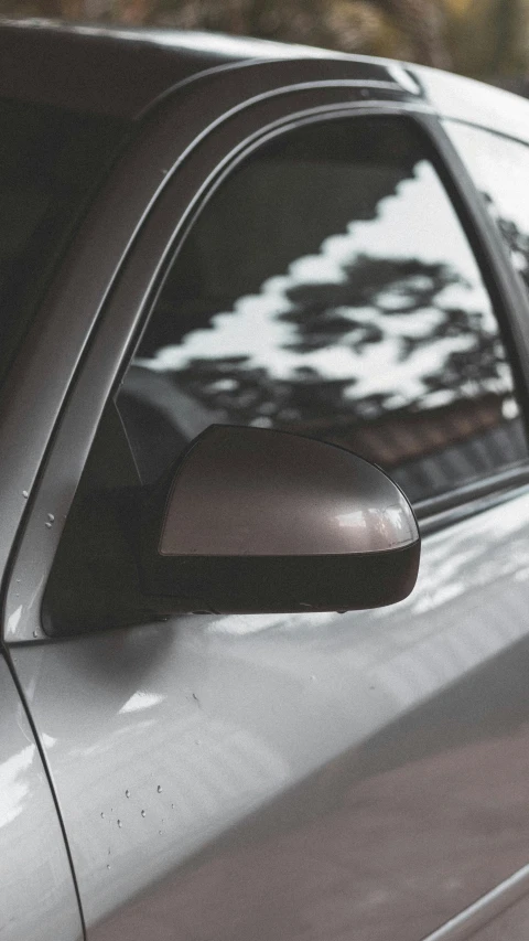 a car window reflecting the side view mirror