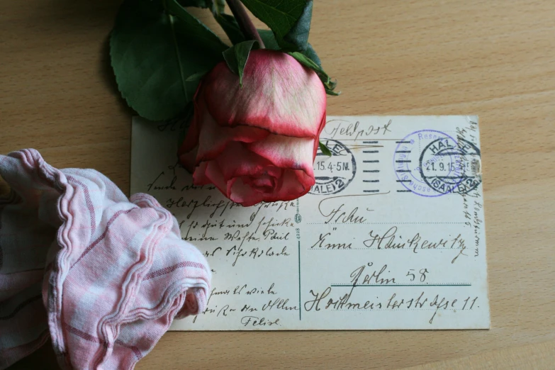 a rose sits on top of a postcards